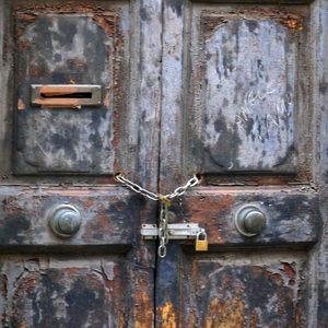 Porte en bois à la peinture décrépie fermée par une chaîne et surmontée d'une grille en fer forgé. - France  - collection de photos clin d'oeil, catégorie portes